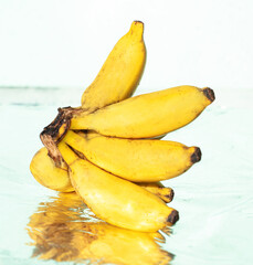 Banany na jasnym tle w świetle dziennym. © insomniafoto