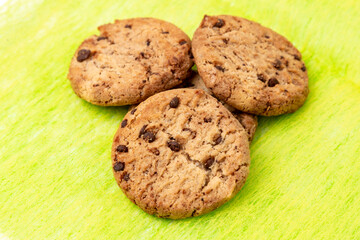 Homemade cookies with chocolate and dried fruit on a yellow tablecloth