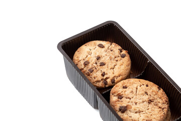 Cookies with chocolate pieces in a plastic containers isolated on a white background