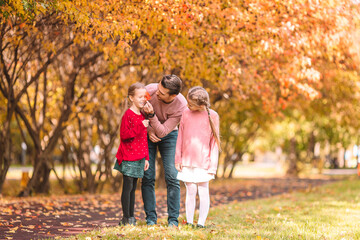 Family of dad and kids on beautiful autumn day in the park