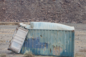 a container tossed on the side of a road in the African desert