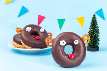 Christmas menu for kids with reindeers made from chocolate doughnut, pretzel cookie, marshmallow and candy,  horizontal