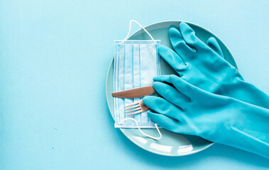 plate with  latex gloves and medical face mask, thermometer, antiseptic - concept of the impact of the coronavirus pandemic on the food service industry