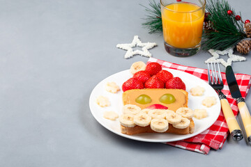 Christmas menu for kids with Santa sandwich made from toast, peanut butter, strawberry, banana, grape and apple, horizontal, copy space