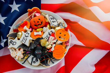 Halloween Jack o Lantern candy bowl with candy and halloween cookies Trick or Treat on patriotic american background, usa flag