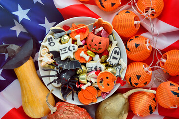 Halloween Jack o Lantern candy bowl with candy and halloween cookies Trick or Treat on patriotic american background, usa flag