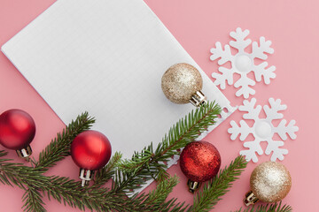 New year concept. Goals list in notepad, gift box and christmas decoration on pink pastel color with copy space