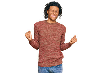 Young african american man wearing casual winter sweater very happy and excited doing winner gesture with arms raised, smiling and screaming for success. celebration concept.