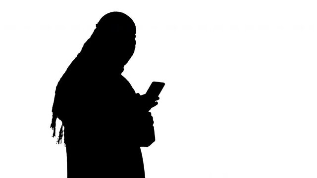 Arab man using his smartphone surfing on the internet or messaging, Alpha Channel