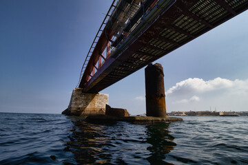 Old huge abandoned rusty bridge above water. Coast. Summer. bridge above the sea. background