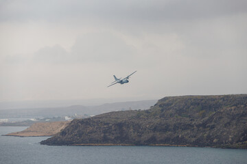 the plane flies across the bay in the ocean