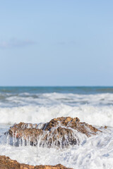 Sea ​​water foam after breaking waves on a rock