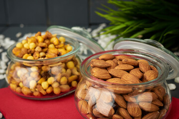 Glass jars with almonds and mixed nuts, ready to taste, on a catering table, to take with drinks
