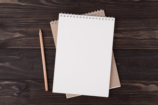 Top above overhead view flat lay photo of a blank notebook and wooden pencil beside isolated on wooden background with copyspace