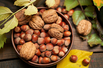 autumn still life in rustic style as a background - leaves, vegetables and fruits, nuts and other natural food ingredients on wooden boards