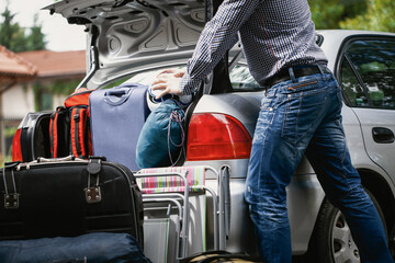 Man trying to fit all his suitcases into car trunk - obrazy, fototapety, plakaty