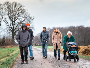 Multi-generational family walking on footpath..