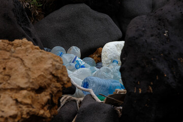 empty plastic bottles thrown between rocks in the desert