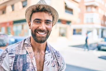 Young hispanic man on vacation smiling happy walking at street of city