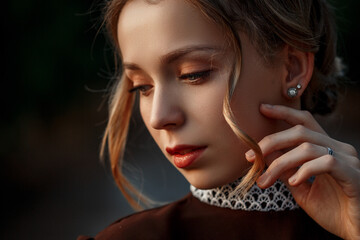 close-up portrait of a young beautiful girl in a brown dress in a retro style on an abandoned road