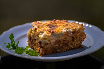 Preparing traditional greek food recipe. Baked pasta casserole pastitsio with rich bechamel sauce and ground beef.