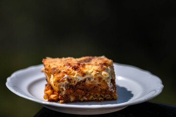 Preparing traditional greek food recipe. Baked pasta casserole pastitsio with rich bechamel sauce and ground beef.