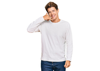 Handsome caucasian man wearing casual white sweater smiling doing phone gesture with hand and fingers like talking on the telephone. communicating concepts.