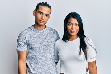 Young latin couple wearing casual clothes relaxed with serious expression on face. simple and natural looking at the camera.