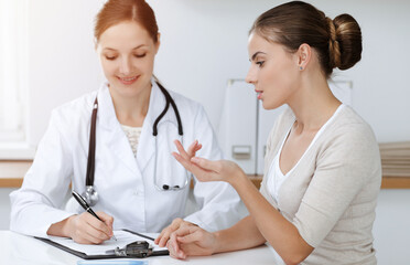 Doctor and patient sitting and discussing health examination results in sunny clinic