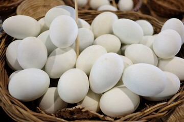 In selective focus many raw eggs in the basket and selling at the organic farm market