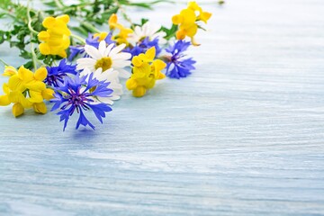 Field flowers bouquet on blue wooden background , Still life with bouquet of wild flowers