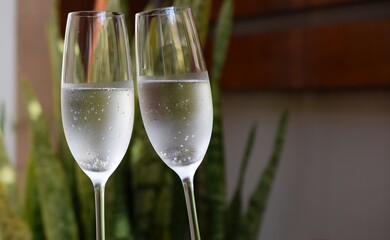 Celebrating the new year with two glasses of white wine with blurred background and space for text.