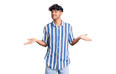 Young hispanic man wearing casual clothes smiling showing both hands open palms, presenting and advertising comparison and balance