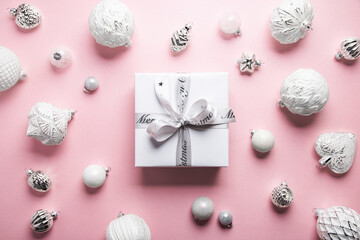 Merry Christmas and Happy Holidays greeting card, frame, banner. New Year. Noel. Christmas white silver ornaments and empty gift box on pink background top view. Winter xmas holiday theme. Flat lay	