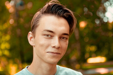 Young pretty man walks in park.