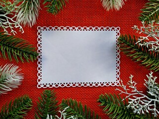 christmas background for postcard. fir branches with elements of Christmas decor on red linen burlap