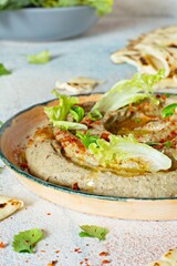 An oriental dish of baked eggplant babaganush (eggplant puree) with spices, herbs, lettuce and oriental flatbreads.