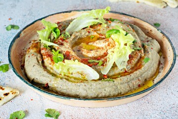 An oriental dish of baked eggplant babaganush (eggplant puree) with spices, herbs, lettuce and oriental flatbreads.