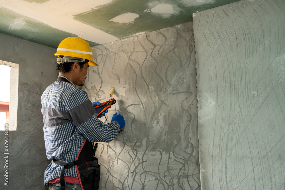 Poster electrician working with switches and sockets of a residential electrical system.