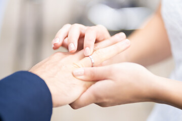 Obraz na płótnie Canvas Ring Ceremony - Woman puts ring on husbands finger