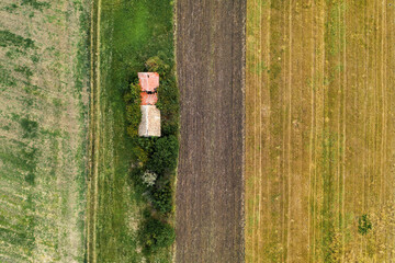 Aerial view of abandoned farm house in the field