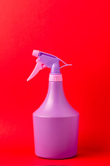 bottle with spray on red grey background/purple spray bottle isolated on red background