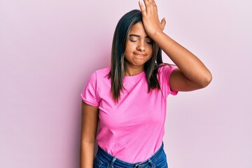 Young latin girl wearing casual clothes surprised with hand on head for mistake, remember error. forgot, bad memory concept.