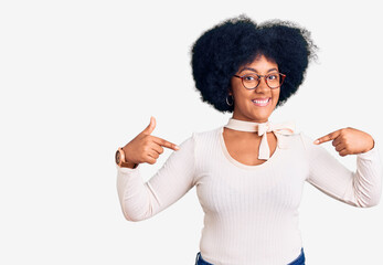 Young african american girl wearing casual clothes and glasses looking confident with smile on face, pointing oneself with fingers proud and happy.