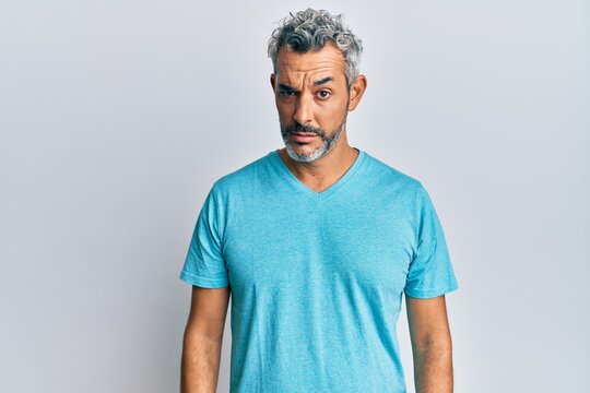 Middle age grey-haired man wearing casual clothes skeptic and nervous, frowning upset because of problem. negative person.