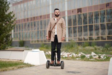 Contemporary young elegant businessman riding gyroscope outdoors