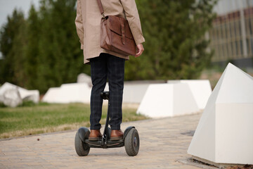 Obraz premium Rear view of contemporary businessman in smart casualwear riding gyroscope