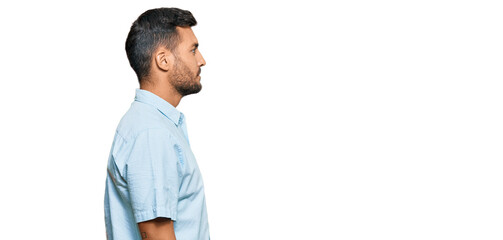 Handsome hispanic man wearing casual clothes looking to side, relax profile pose with natural face...