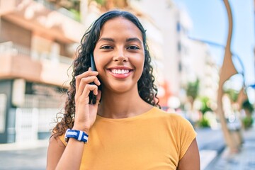 Young african american girl smiling happy talking on the smartphone at city.