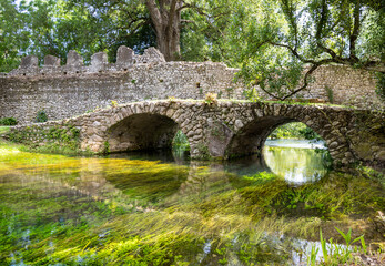 Fototapeta na wymiar Garden of Ninfa and ruins of the medieval city Ninfa in Italy in the province of Latina. Most beautiful and romantic gardens in the world.